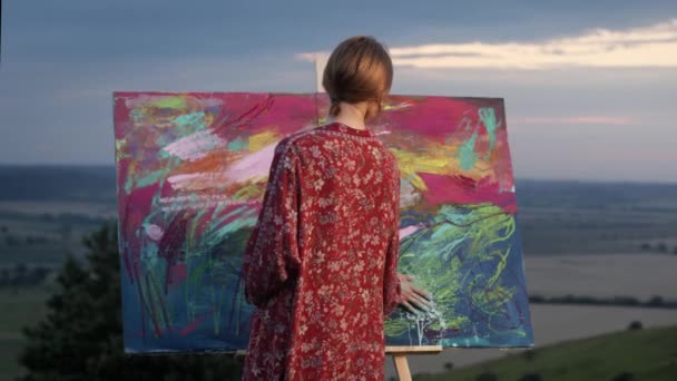Fille artiste peint tableau avec sa main trempée dans la peinture. — Video