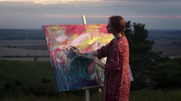 Chica artista pinta cuadro con sus manos sumergidas en pintura. — Vídeo de stock
