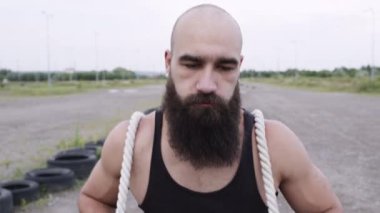 Atletik Adam Spor İçin Gidiyor. Adam koşar ve arabanın lastiklerini ipe bağlar.