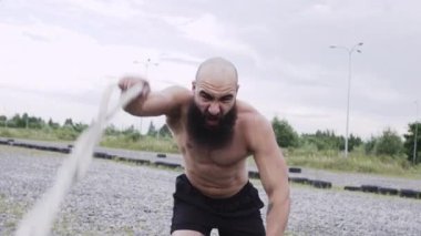 Atletik Adam Spor İçin Gidiyor. Adam ipleri elinde tutar ve hareket ettirir..