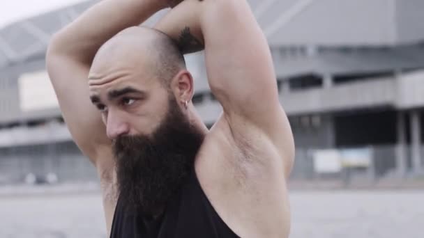 Sportler trainiert auf der Straße. Kerl mit Bart macht Handbewegungen. — Stockvideo
