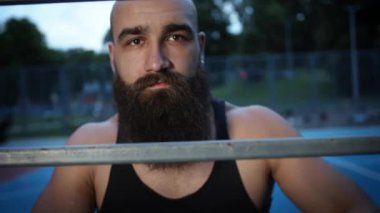 Spor sahasındaki genç adam spor yaparken dinleniyor..