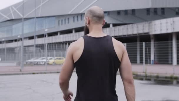 Junger Sportler geht die Straße entlang. — Stockvideo