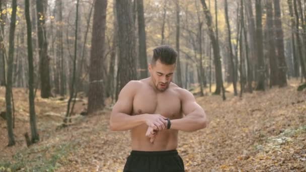 Młody człowiek robi ćwiczenia w lesie. — Wideo stockowe