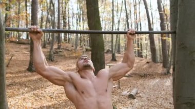 Güçlü Çıplak Adam Direk 'te duruyor. Egzersiz, erkeğin tüm kaslarını vurgular.