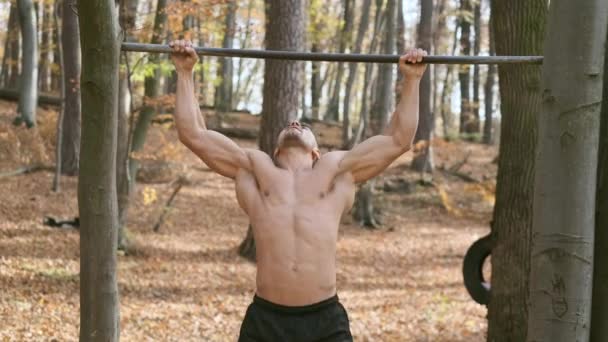Stark naken kille drar upp på Pole. Motion betonar alla musklerna i mannen — Stockvideo