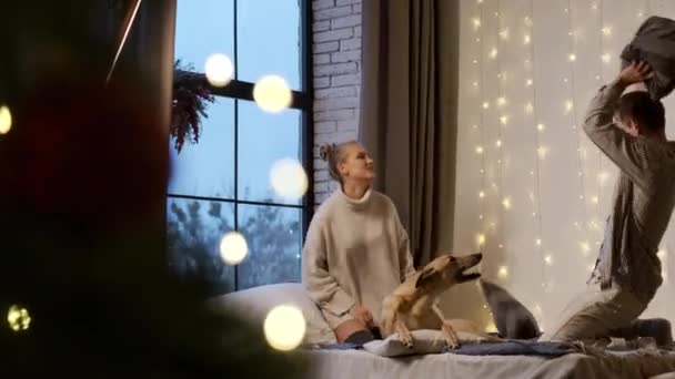 Nový rok. Mladý pár na silvestra doma se svým psem. — Stock video