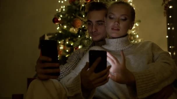 Ano Novo. Casal jovem com telefones celulares em mãos. — Vídeo de Stock