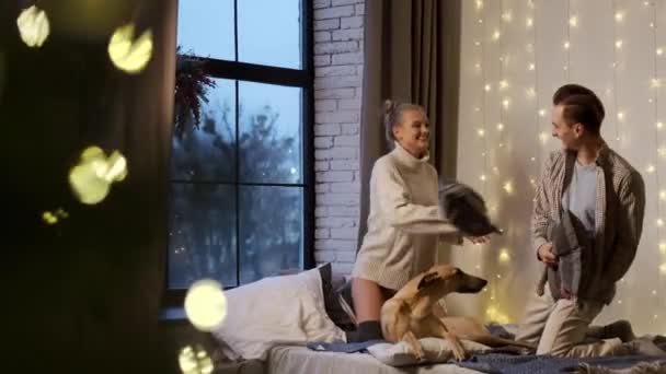 Nouvel An. Jeune couple sur la veille du Nouvel An à la maison avec leur chien. — Video
