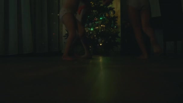 Nowy Rok. Dzieci biegające w pokoju obok choinki. Pokój jest Gark. — Wideo stockowe