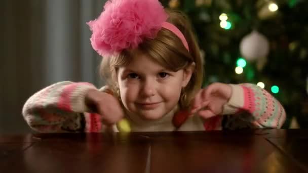 Újév. Csinos kislány ül az asztalnál.. — Stock videók