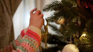 Yeni yıl. Anne ve küçük kızı Noel ağacını süslüyor..