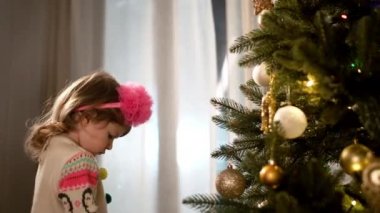 Yeni yıl. Genç Anne, Noel ağacının yanında duran küçük kızı rahatsız ediyor..