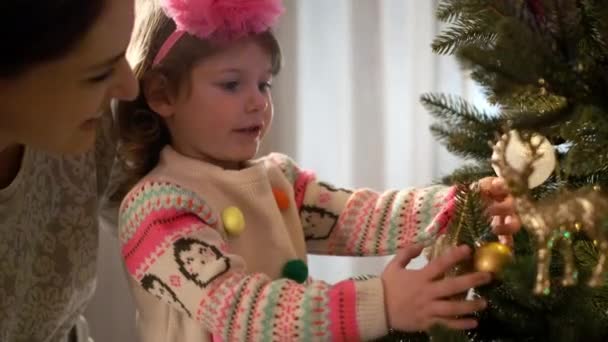 新年。母と娘はクリスマスツリーを飾る. — ストック動画