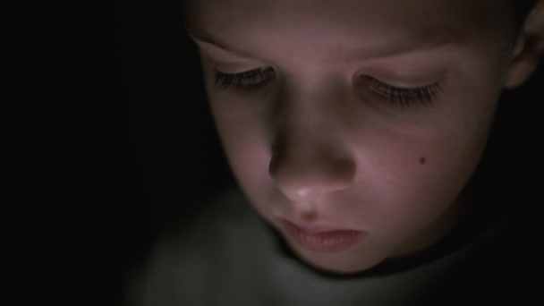 Обличчя хлопчика в темряві ігри на планшеті . — стокове відео