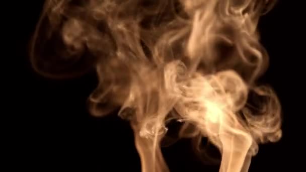 Strom orangefarbenen Rauchs auf schwarzem Hintergrund steigt auf. — Stockvideo