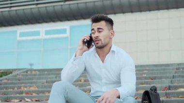 Binanın merdivenlerinde oturan genç adam..