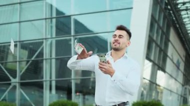 İş dünyasındaki genç adam elbiselerini sokağa fırlatıyor.