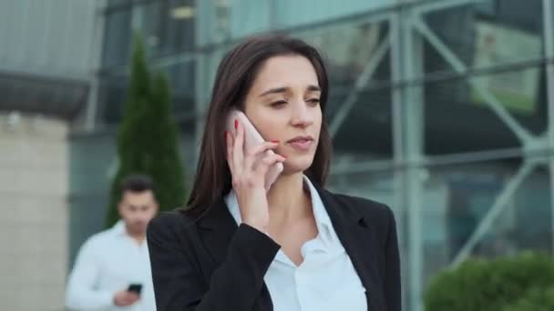 Jovens empresários na rua. Estão a descer a rua. Menina conversando no telefone — Vídeo de Stock