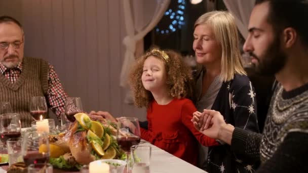 新年の夕食。食べ物を手にする前に祈る家族. — ストック動画