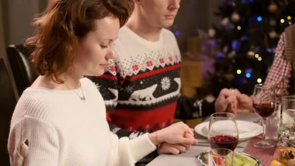 Nyårsmiddag. Familjen ber innan maten håller händerna. — Stockvideo