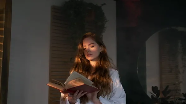 Pen jente med langt hår leser bok. – stockfoto