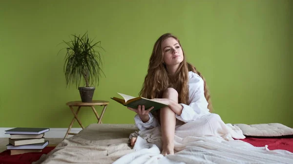 อรุณสวัสดิ์ ของ ยัง ผู้หญิง ใน เตียง กับ หนังสือ ใน เธอ มือ . — ภาพถ่ายสต็อก