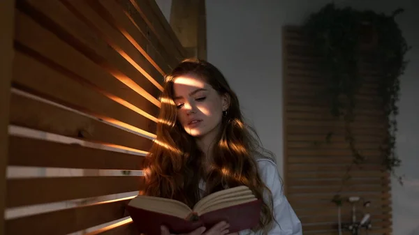 Pen jente med langt hår leser bok. stockbilde