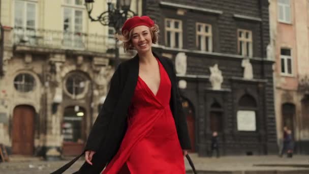 Mujer sexy en rojo camina por la calle de la ciudad. — Vídeo de stock