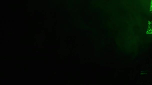 흑색 배경에서 연기의 추상적 인 형태. 밝은 녹색이 연기를 밝히다. — 비디오