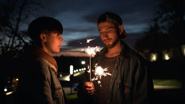Nuori pari kanssa sparklers ulkona yöllä. — kuvapankkivalokuva