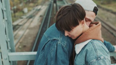 Sevgili ve kız arkadaş köprüde buluşacağız. Kısa saçlı şık bir kız ve şapkalı bir adam..