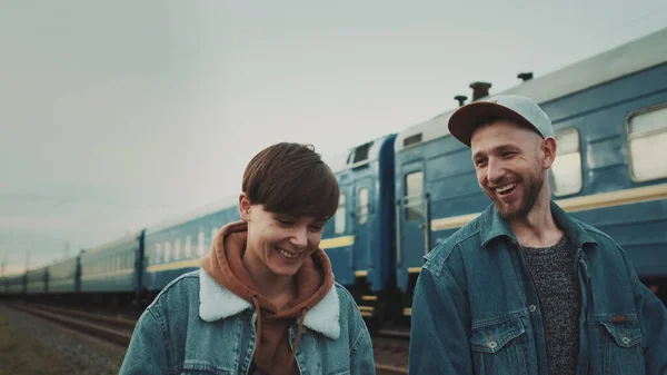 Nuori pari kävelee rautatiellä ja puhuu. — kuvapankkivalokuva
