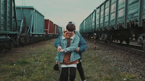 Urban Love Story. Een jong stel dat langs de spoorweg loopt en praat. Ze knuffelen.. — Stockfoto