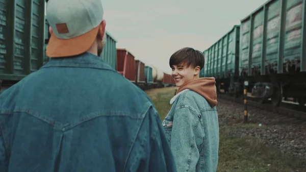 Urban Love Story. Datum Junges Paar auf der Eisenbahn. Eisenbahnwaggons umgeben sie. — Stockfoto