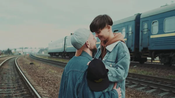 Guy en meisje staan op het spoor. Op de andere spoor trein gaat snel. — Stockfoto