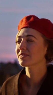Şehir caddesinde dikilen ve bir yerlere bakan genç bir kadın. Dikey Video Çerçevesi.