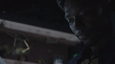 A solitary and contemplative figure, lost deeply in thought, illuminated gently by soft light in a dark environment