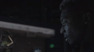 A pensive individual illuminated gently by soft lighting, completely immersed in deep thought and concentration