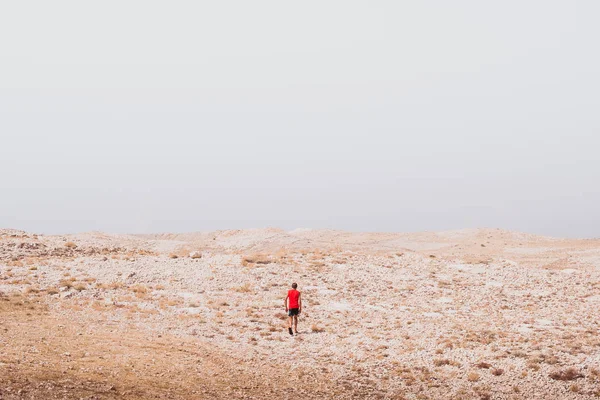 exploring - lonely human walking in a rocky desert - freedom and adventure lifestyle and sport concepts