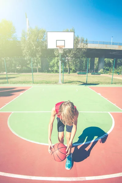 happy teenager play basketball outdoor - healthy sporty teenagers lifestyle concept in spring or summer time