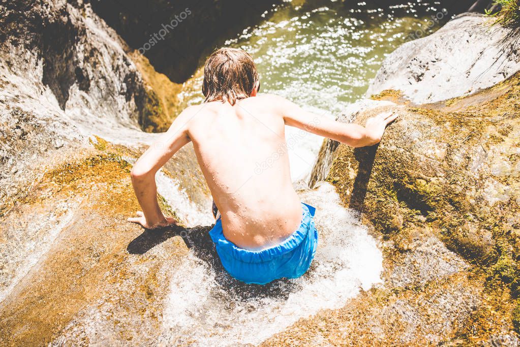 young boys have fun at the small river - outdoor summer activities - fun in the nature concept