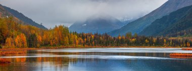 Alaska 'da sonbahar zamanı alçak seviye bulutlu Tern Gölü manzarasının süper panoramik görüntüsü.