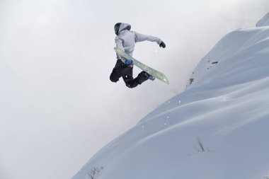 Dağlarda uçan snowboardcu. Olağanüstü kış sporu.