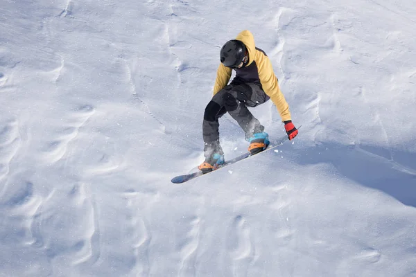 Um snowboarder voador nas montanhas. Extremo esporte de inverno. — Fotografia de Stock