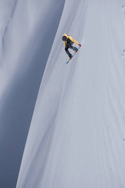 Repülő snowboardos a hegyekben. Extrém téli sport. — Stock Fotó