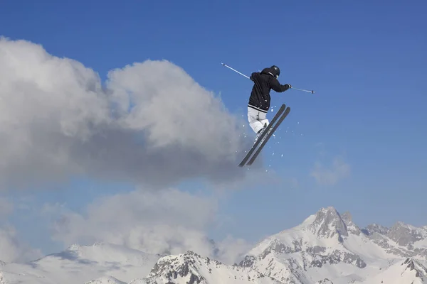 Lentävä hiihtäjä lumisilla vuorilla. Äärimmäinen talviurheilu, alppihiihto . — kuvapankkivalokuva