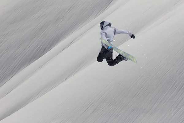 Сноубордист летить на тлі сніжного схилу. Екстремальні зимові види спорту, сноубординг . — стокове фото