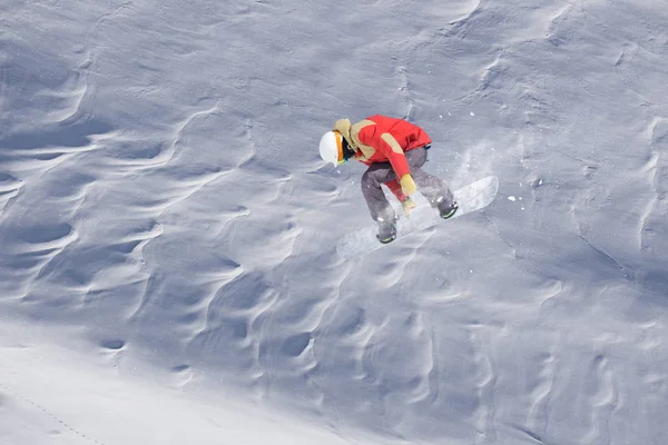 Snowboarder vliegen op de achtergrond van besneeuwde helling. Extreme wintersporten, snowboarden. — Stockfoto