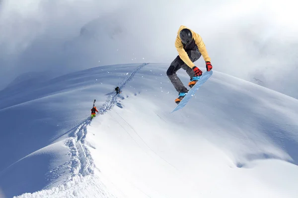Esquiadores escalando uma montanha nevada — Fotografia de Stock
